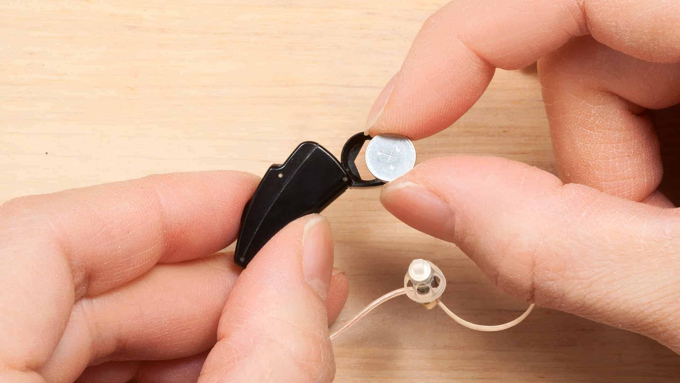 Batterie für Hörgeräte, kleine Knopfzelle, in Hand gehalten.