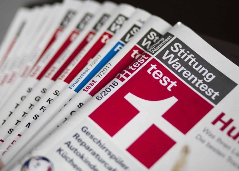 Ein Stapel Zeitungen mit Testberichten zu Stiftung Warentest, Fokus auf Hörgeräte.