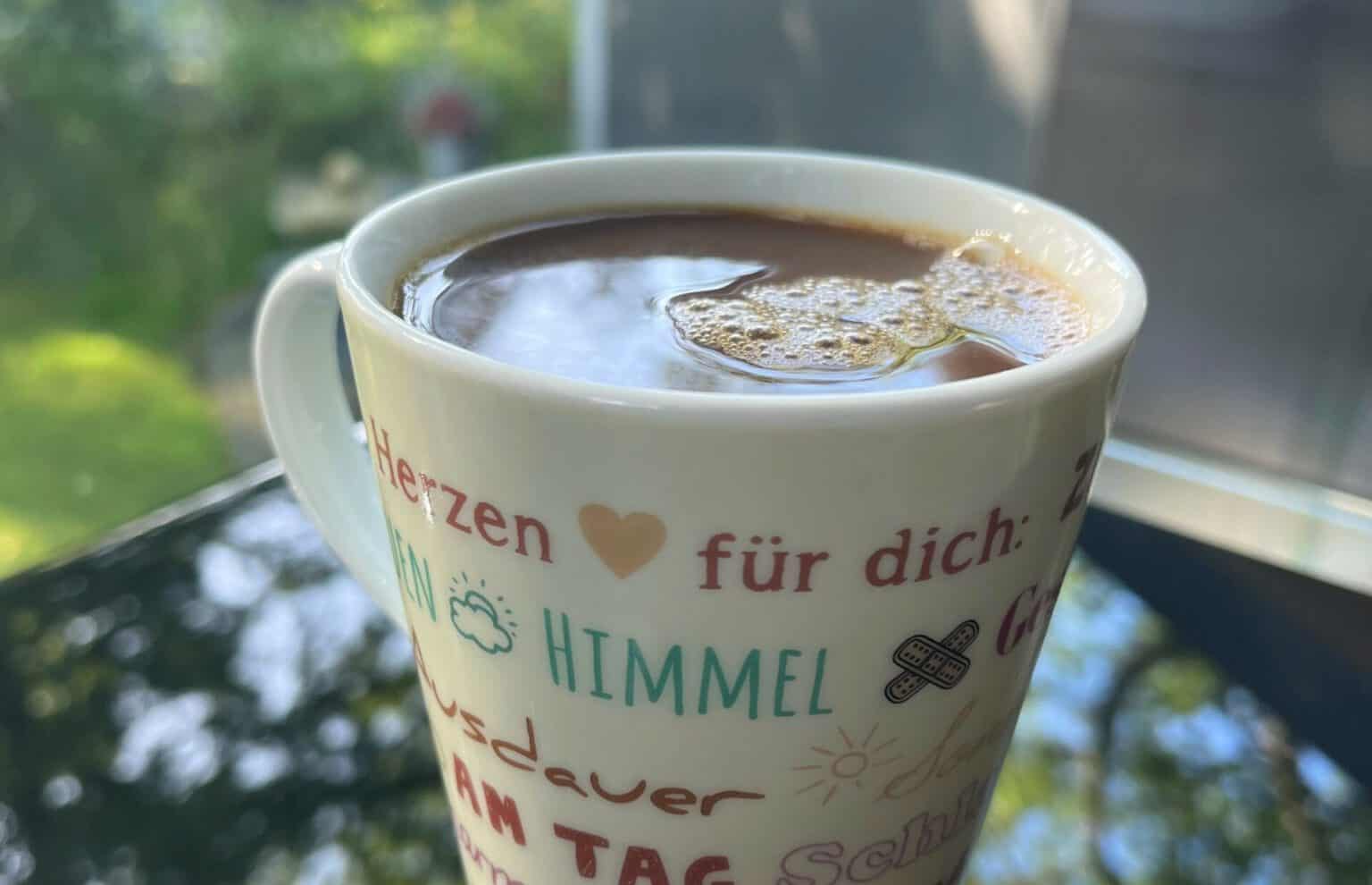 Herzlicher Kaffeebecher mit liebevollen Worten und Symbolen, ideal für den Start in den Tag.