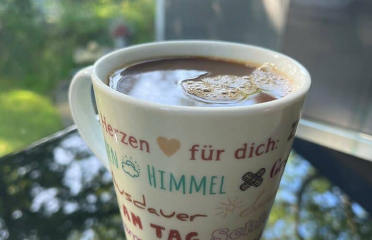 Herzlicher Kaffeebecher mit liebevollen Worten und Symbolen, ideal für den Start in den Tag.