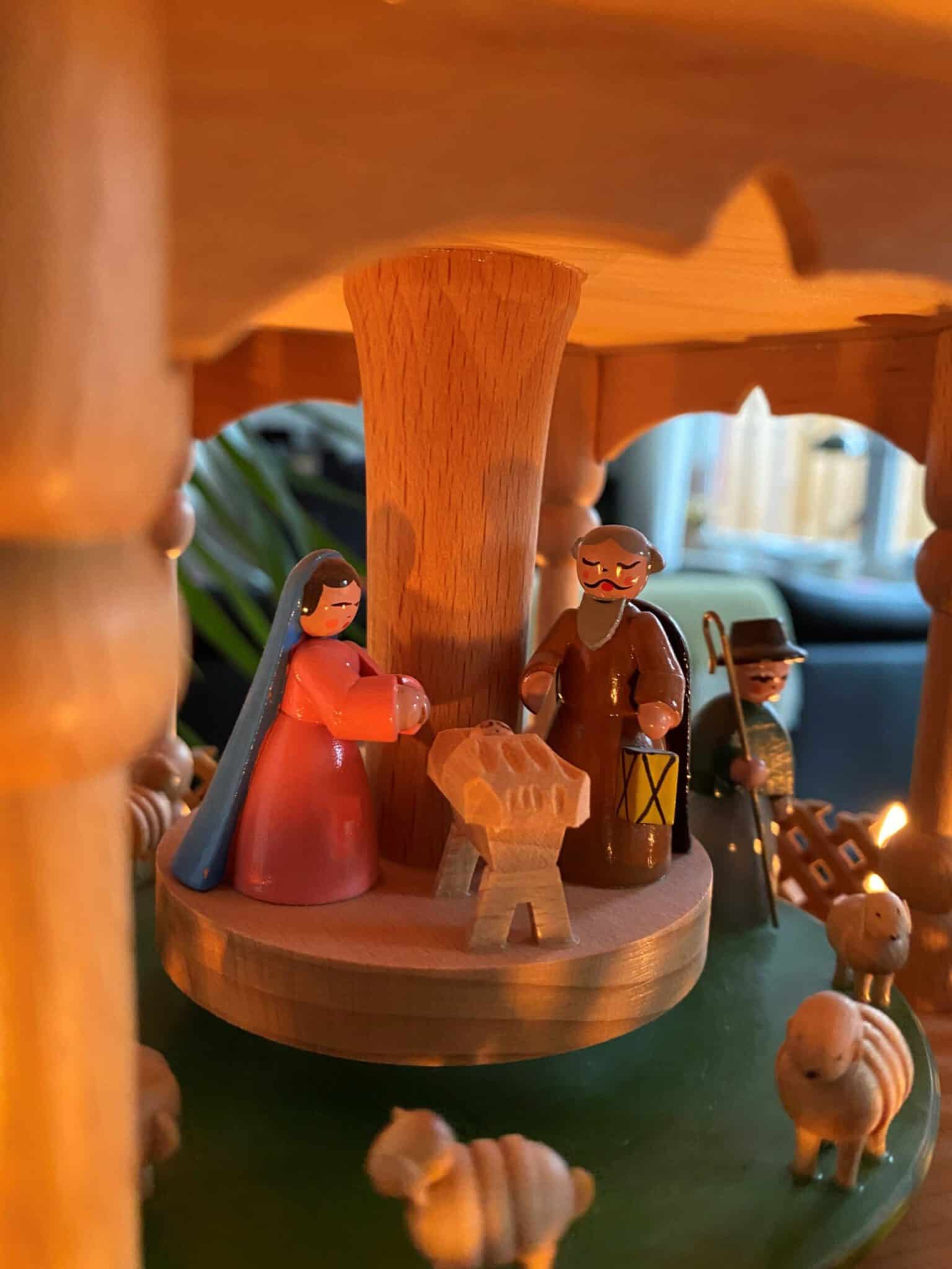 Hochwertiges Holzkrippenfiguren-Set unter einem Weihnachtsbaum, symbolisiert die Geburt Jesu.