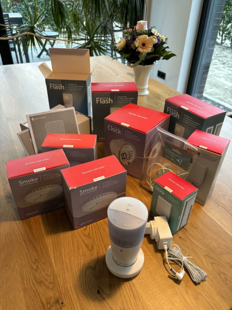 Lichtsignale und Rauchmelder in Verpackungen auf einem Holztisch, bereit für die Installation.