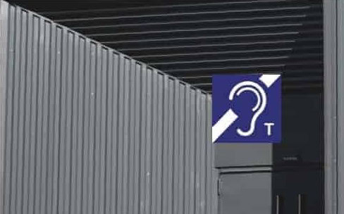 Höranlage-Symbol an einer Gebäudewand, barrierefreie Kommunikation für Schwerhörige.