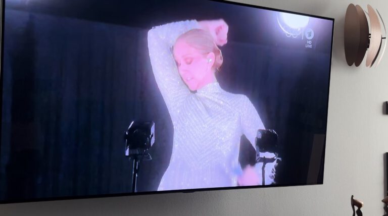 Celine Dion bei einem Auftritt, mit geschlossenen Augen und Hand im Haar.