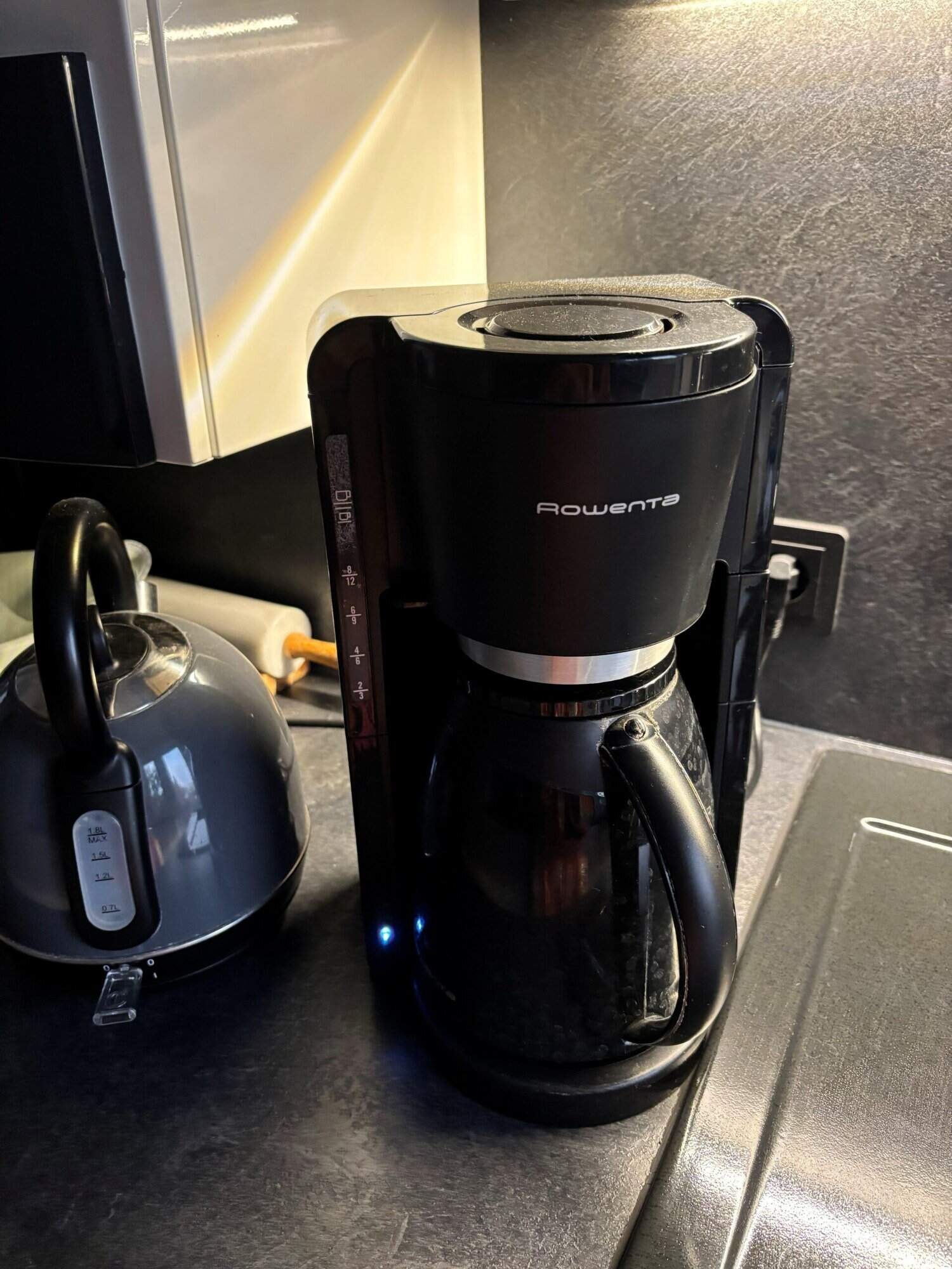 Kaffeemaschine auf einer Küchenarbeitsplatte, schwarz und modern gestaltet.